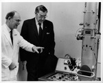 Dr. Carl Hoffman examining electron microscope, St. Paul's Hospital, London