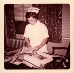 Dr. Carl Hoffman's head nurse, Annie Weber, working on his scrapbooks