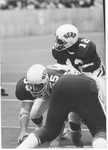 Center Dennis Foley (#55) centers ball to Bob Harris (#12),1970 MU Football team